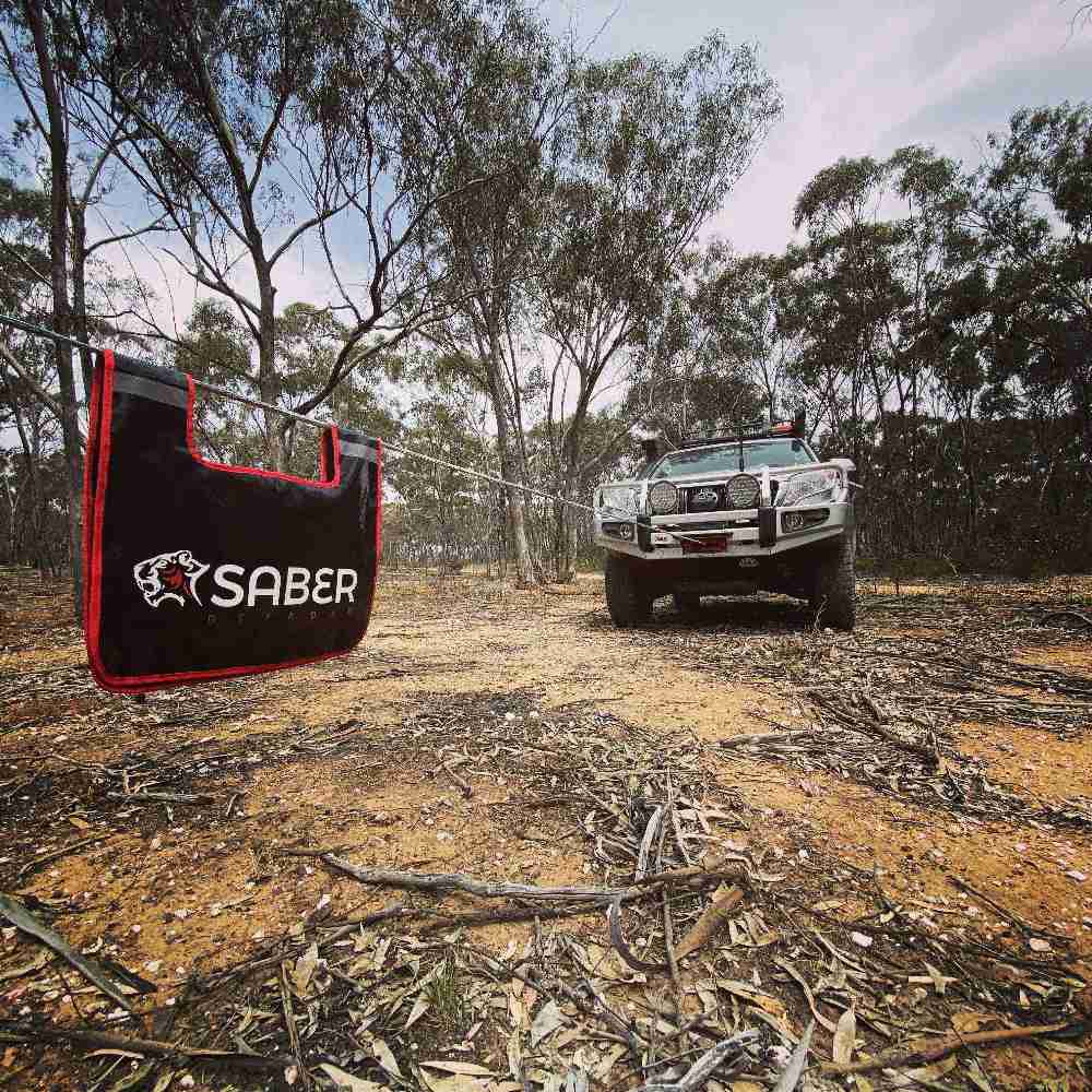 Saber product being used in an outdoor setting with a vehicle in the background.