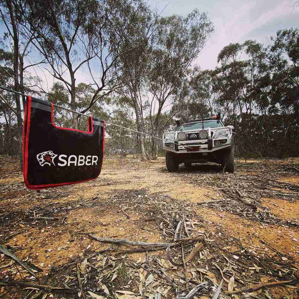 Saber product being used in an outdoor setting with a vehicle in the background.